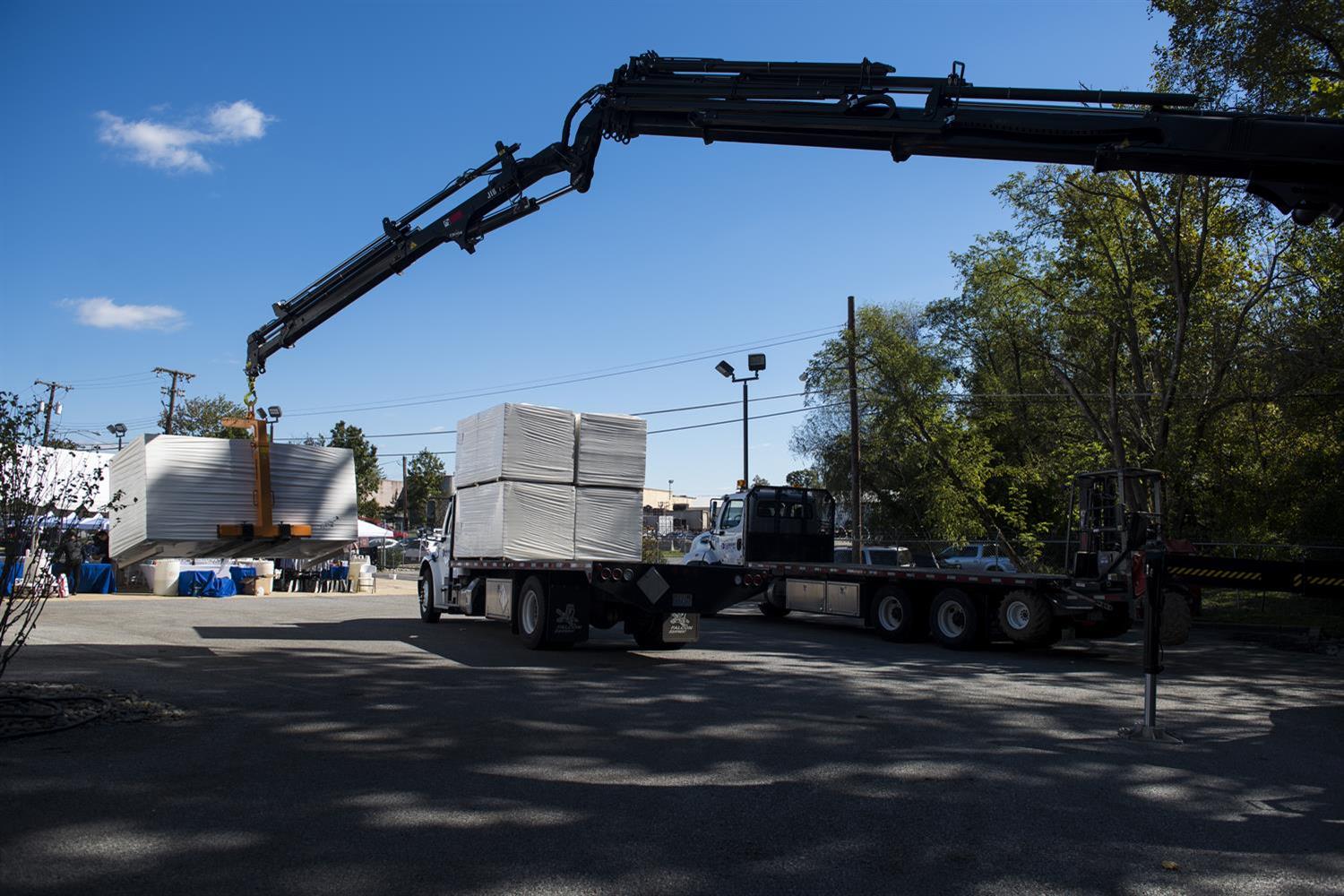 A crane loading a truck with insulation